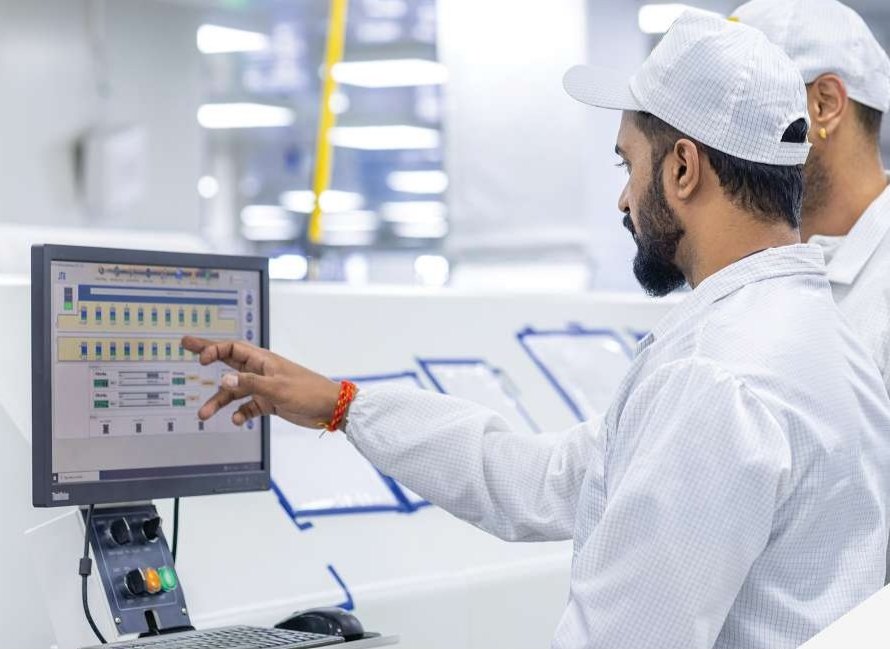 A technician at the control screen of an automated surface-mount line in India